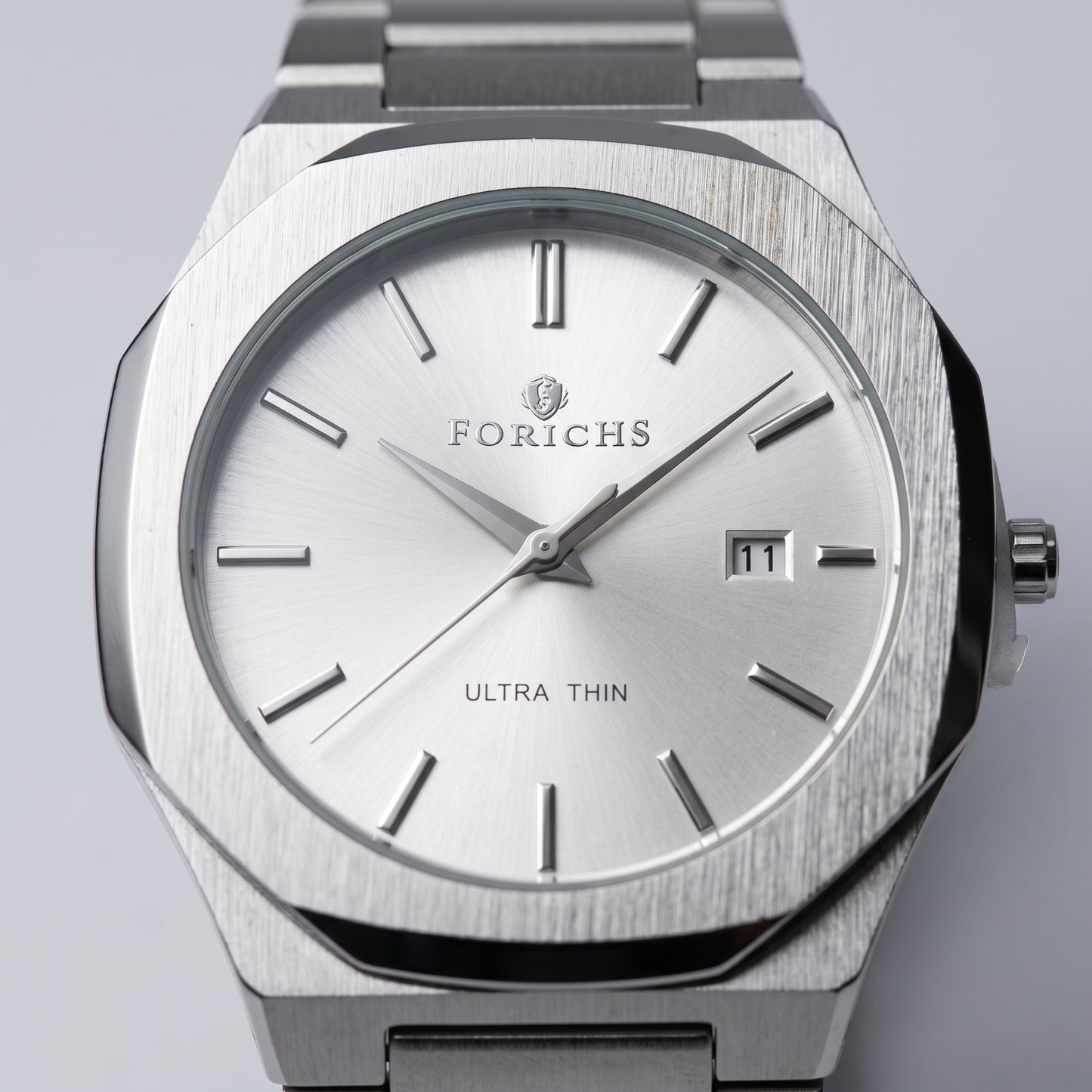 Close-up of FORICHS silver steel watch dial with date window and sapphire glass
